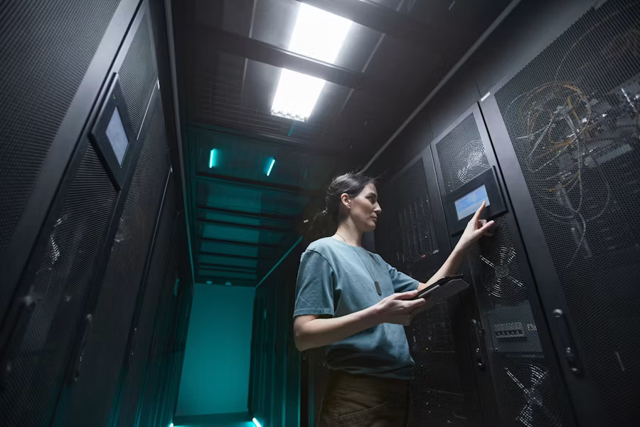 Female data center technician operating server equipment